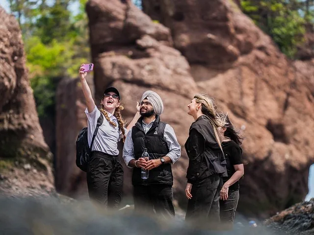 Gruppo di amici che si scatta un selfie con i Flowerpot Rocks a Hopewell Rocks.